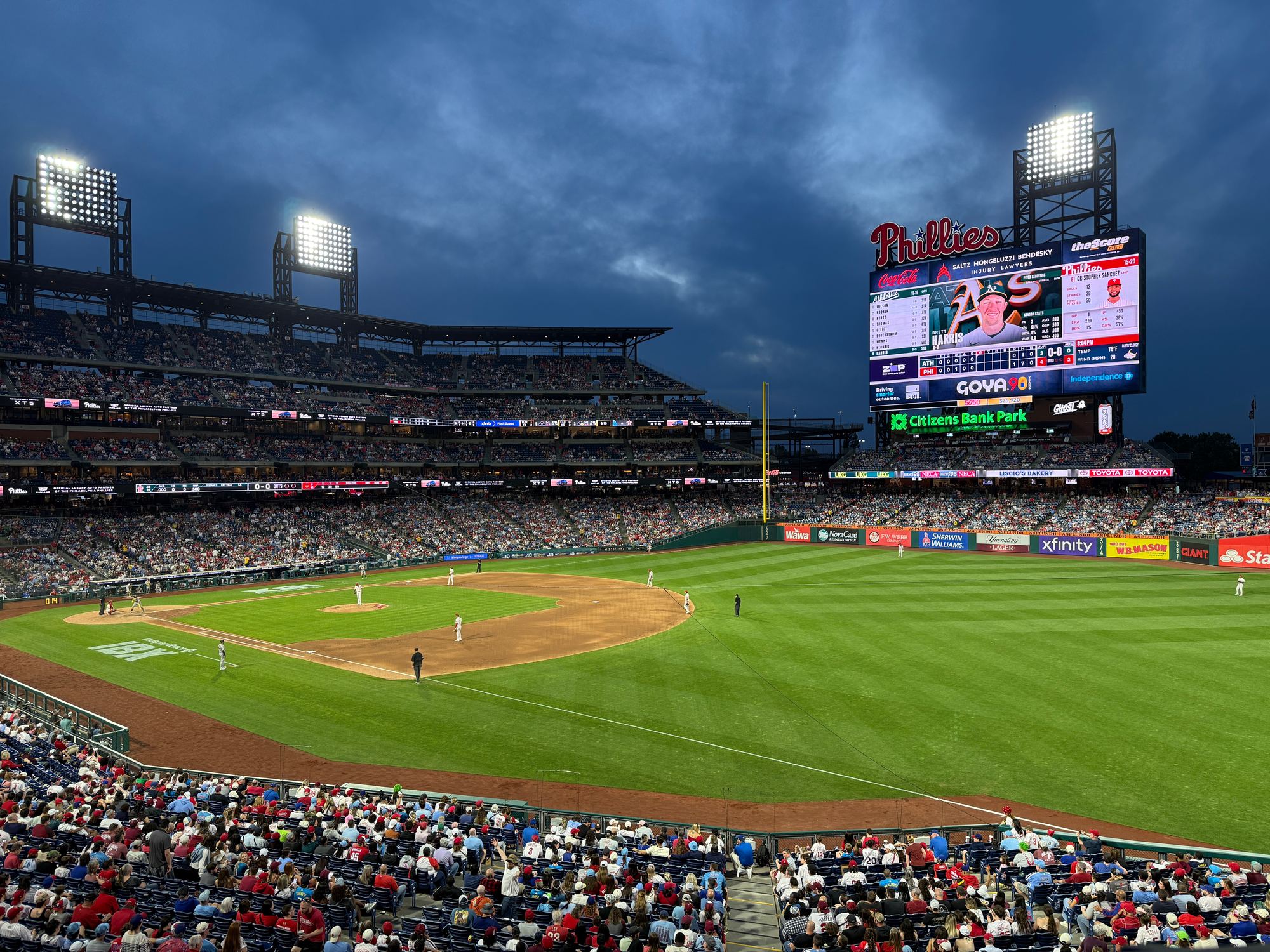 Citizens Bank Park during a night game, with the lights on under a cloudy sky