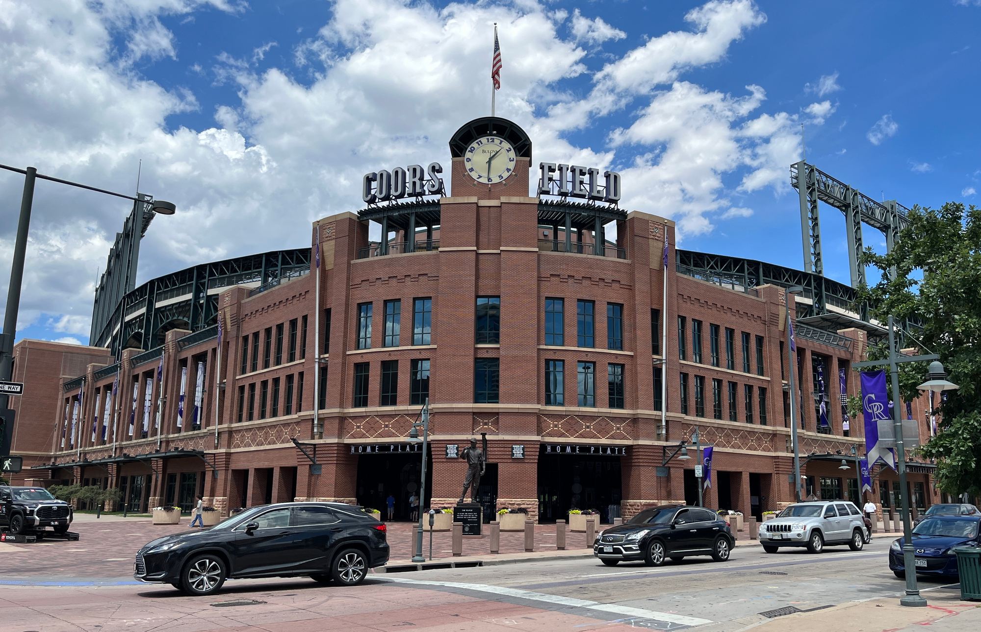 The brick main entrance and clock tower at Coors Field on a sunny day