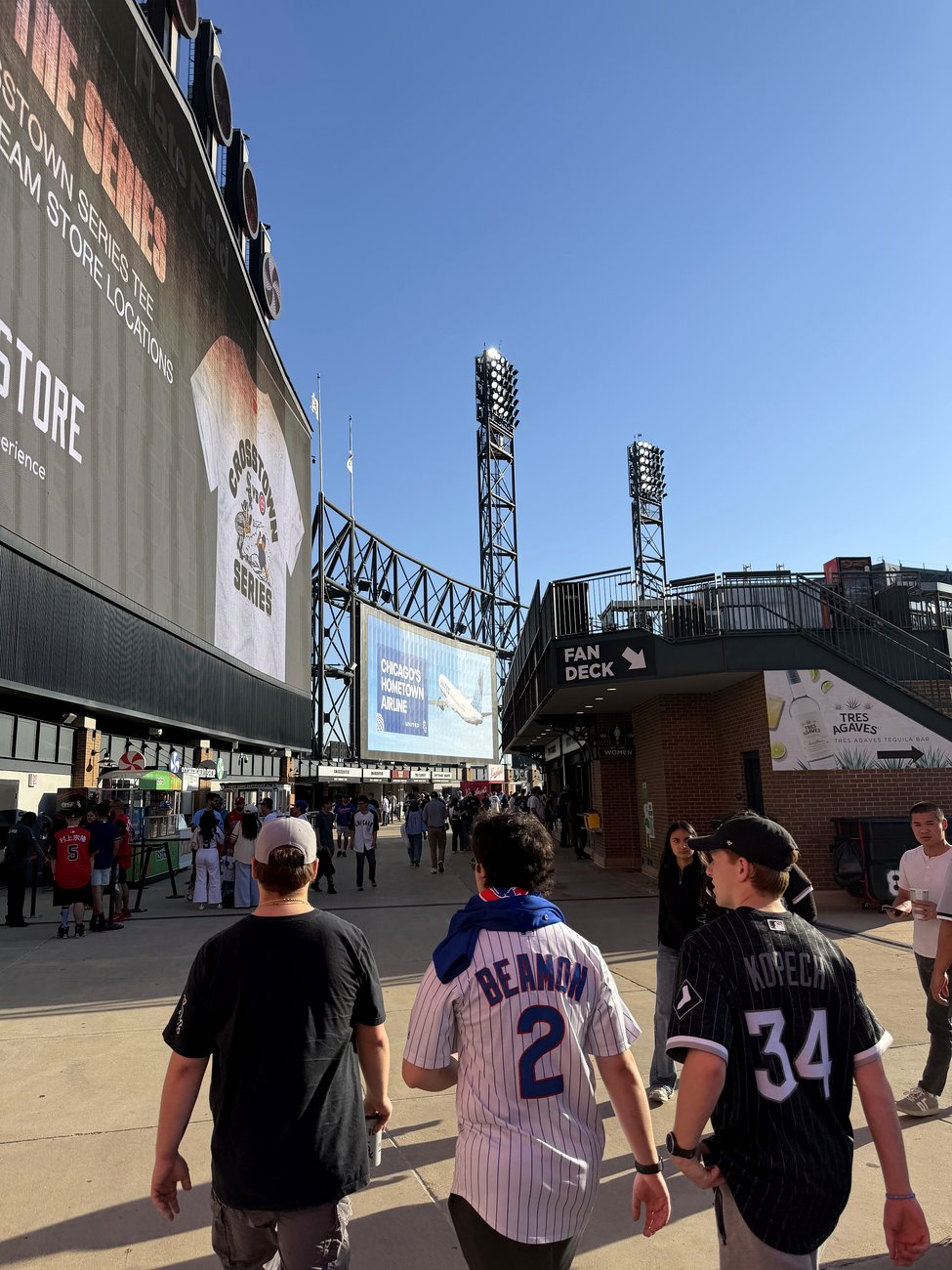Cubs fans in road jerseys walking the Rate Field concourse on Crosstown Classic day