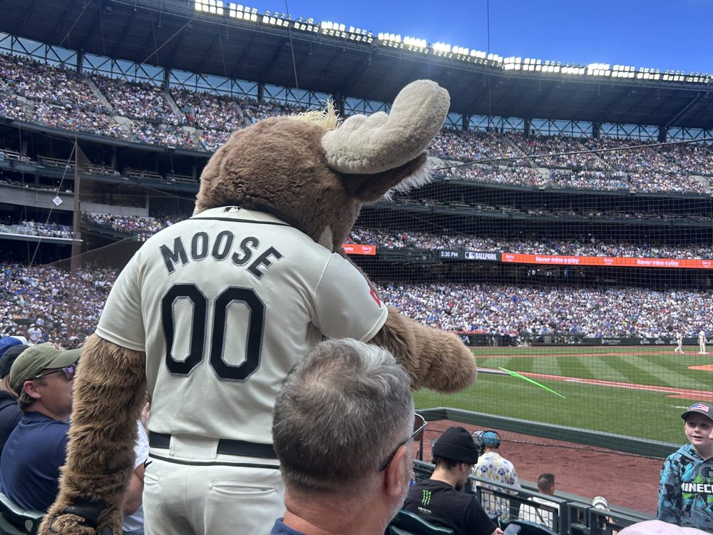 The Mariner Moose mascot in a number 00 jersey among fans in the lower seats at T-Mobile Park