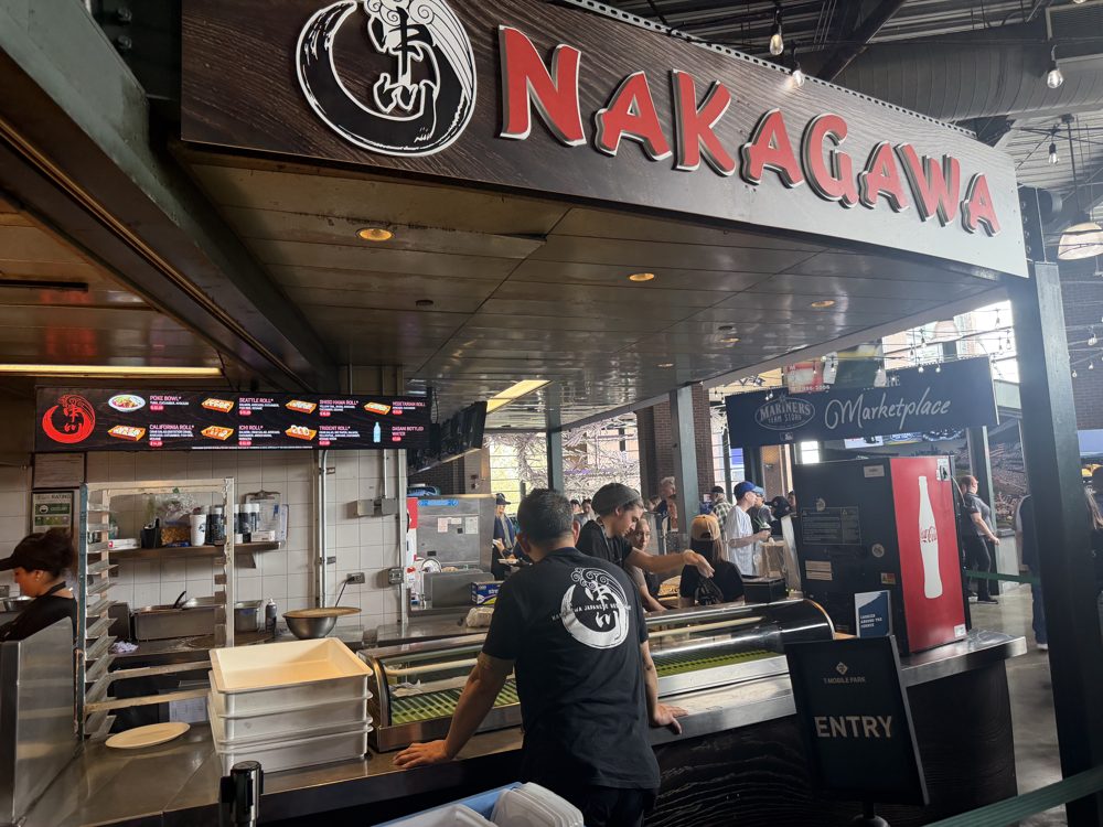 The Nakagawa sushi stand at T-Mobile Park, its red lettered sign over a counter with staff at work