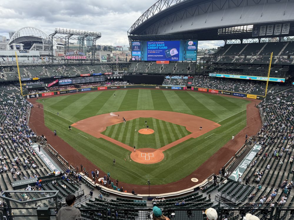 The whole diamond from the View Level behind home plate at T-Mobile Park, with the downtown skyline and the parked roof beyond the outfield