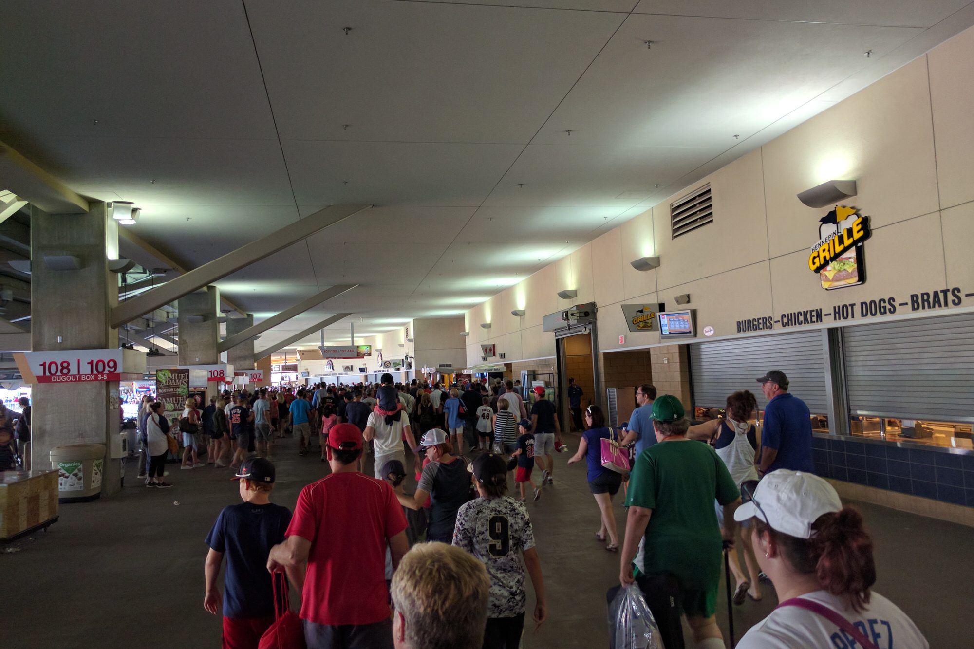 The Main Concourse at Target Field during a game, fans walking past a concession stand with its menu board overhead