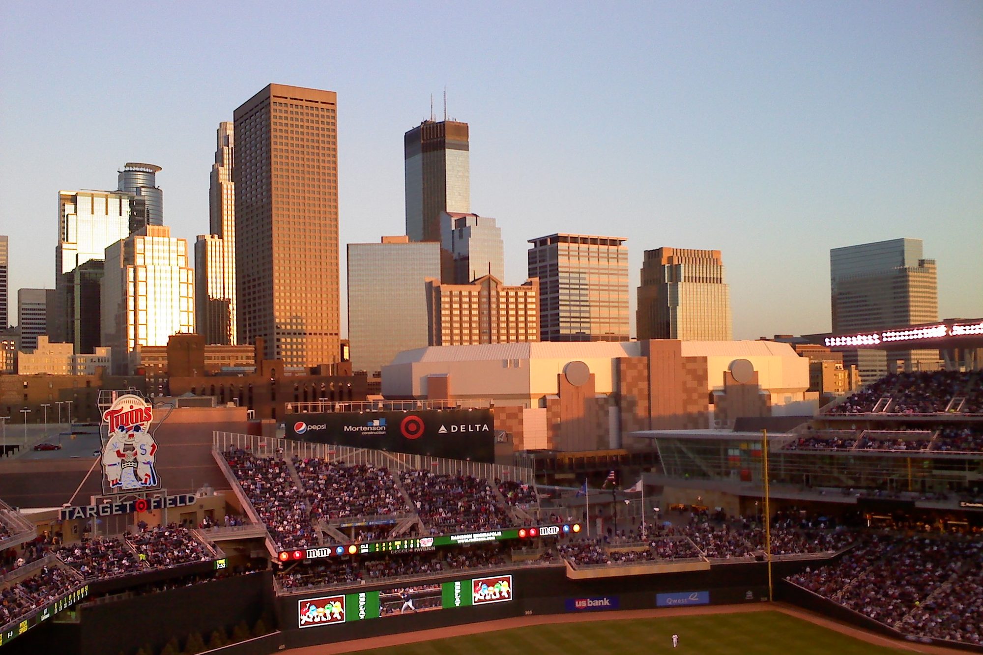 The downtown Minneapolis skyline at sunset seen over the outfield from inside Target Field