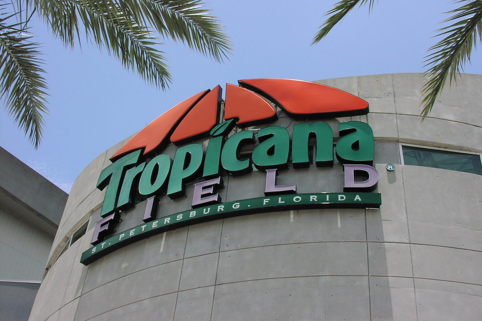 The Tropicana Field sign above the entrance, the curved concrete facade of the dome behind it
