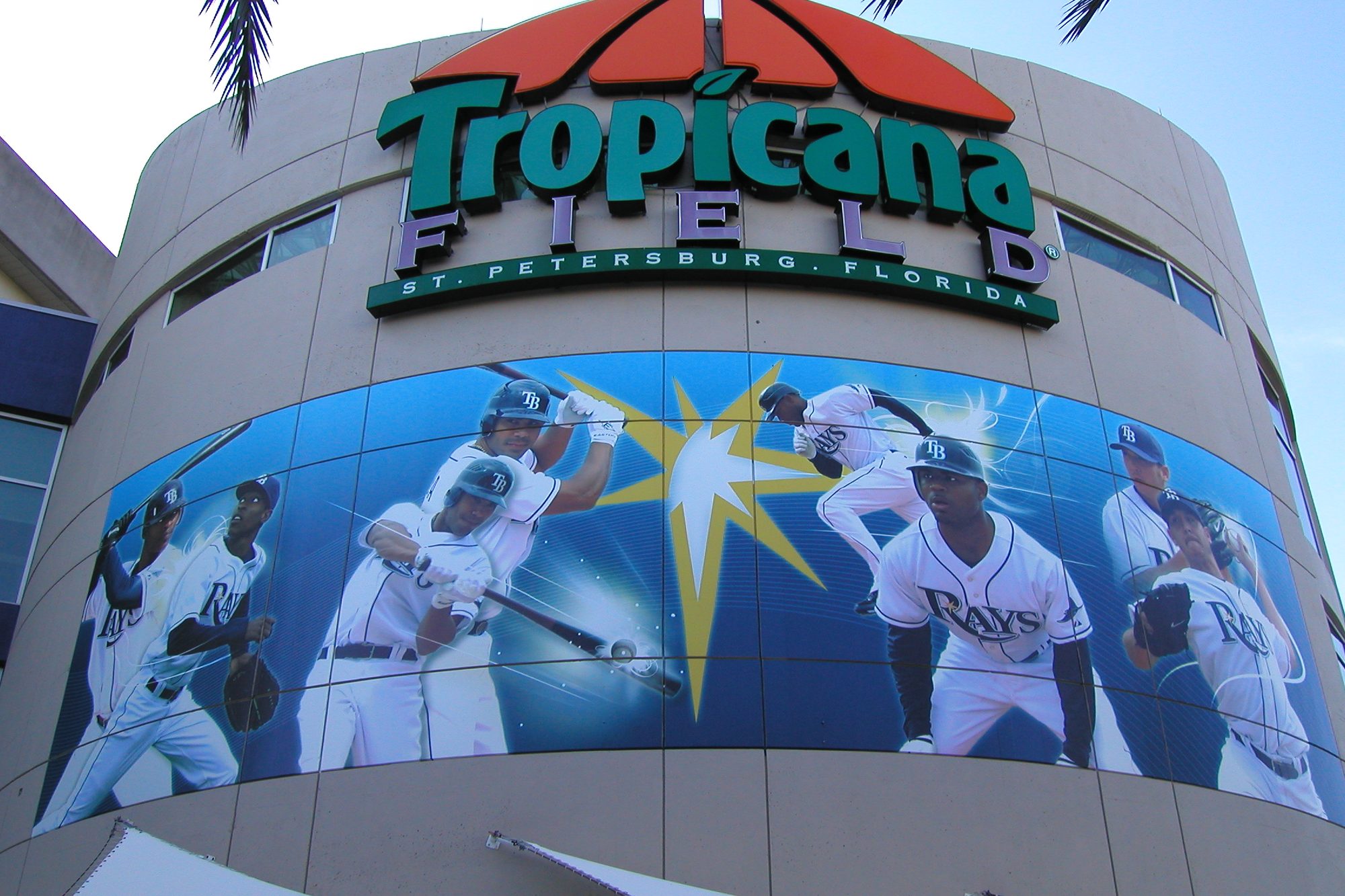 The entrance rotunda at Tropicana Field, a mural of Rays players wrapping the curved facade beneath the Tropicana Field sign