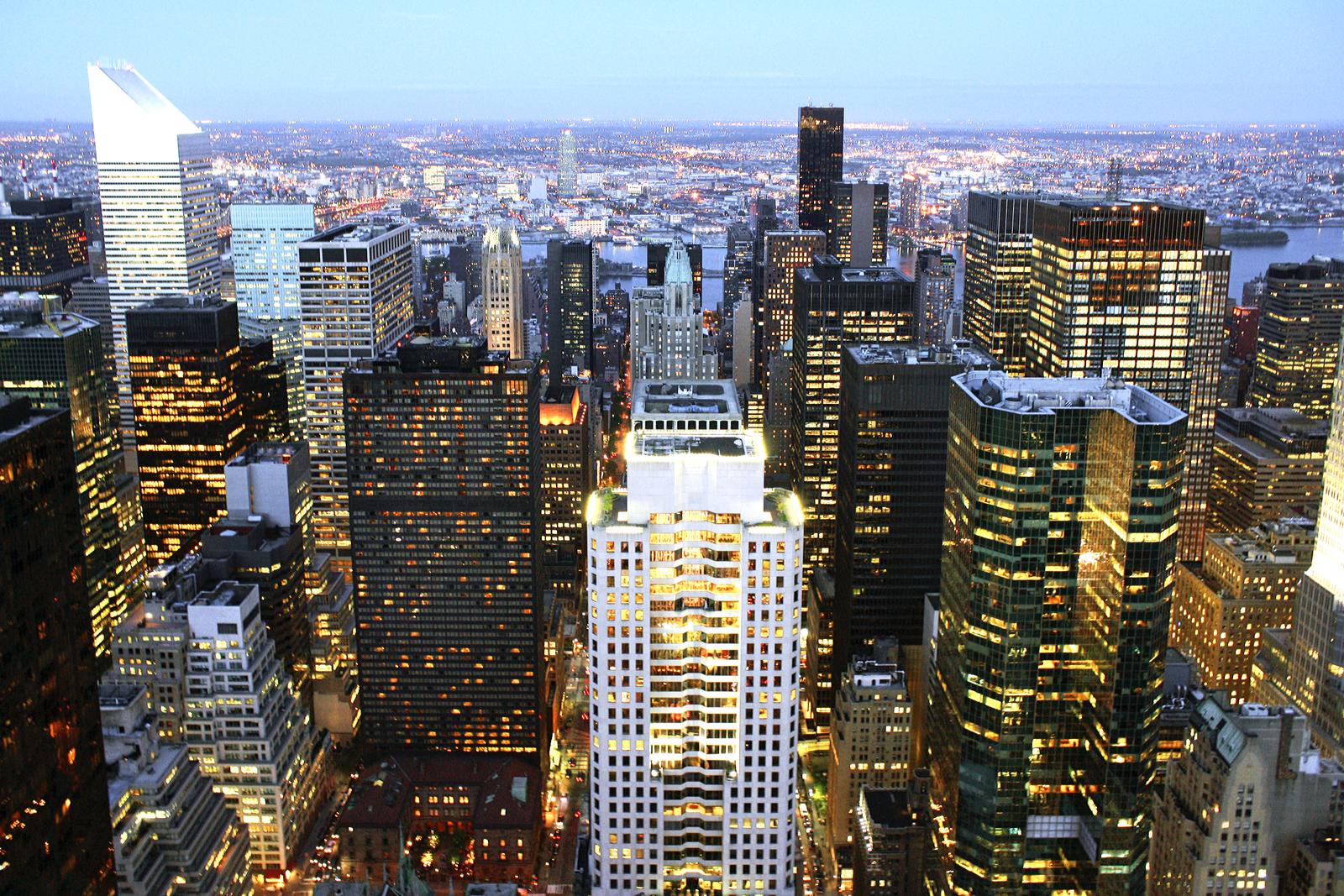 Lit office and hotel towers in Midtown Manhattan seen from above at night
