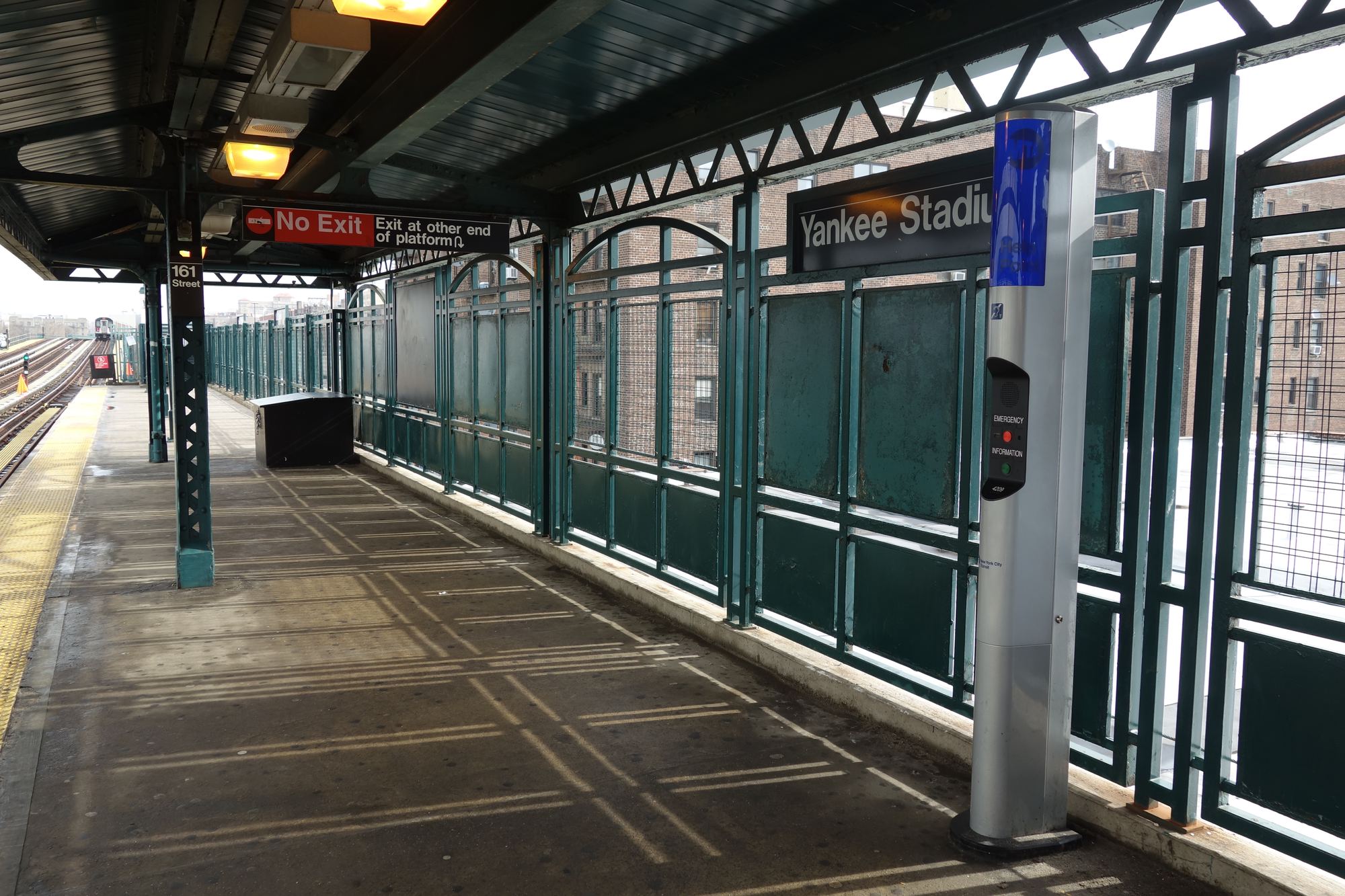 The elevated subway platform at 161st Street, with a Yankee Stadium station sign on the fence